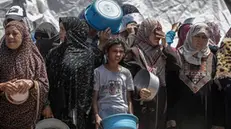 epa12086530 Internally displaced Palestinians wait to receive a portion of food from a charity kitchen, in Jabalia refugee camp, northern Gaza Strip, 09 May 2025. According to the UN Palestinian refugee agency UNRWA, over a million people across the Gaza Strip are experiencing 'high levels' of acute food insecurity, with acute malnutrition several times higher than before the war. The UN estimates at least 1.9 million people (nine in ten) are internally displaced. EPA/MOHAMMED SABER