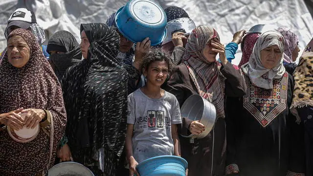 epa12086530 Internally displaced Palestinians wait to receive a portion of food from a charity kitchen, in Jabalia refugee camp, northern Gaza Strip, 09 May 2025. According to the UN Palestinian refugee agency UNRWA, over a million people across the Gaza Strip are experiencing 'high levels' of acute food insecurity, with acute malnutrition several times higher than before the war. The UN estimates at least 1.9 million people (nine in ten) are internally displaced. EPA/MOHAMMED SABER