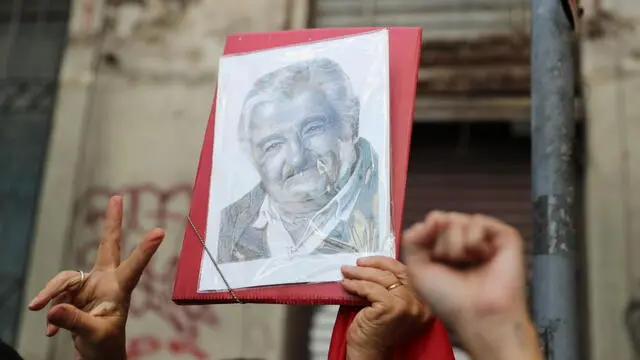 epa12100100 A person holds a portrait during the funeral procession of former Uruguayan president Jose Mujica in Montevideo, Uruguay, 14 May 2025. Mujica died at the age of 89 on 13 May 2025. EPA/ALEJANDRO PRIETO