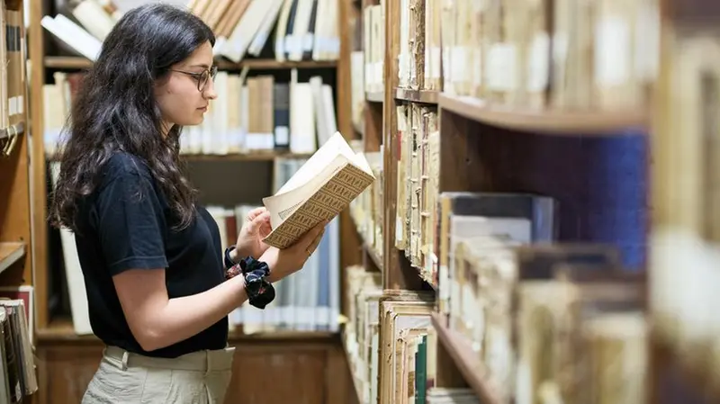 Una studentessa in biblioteca