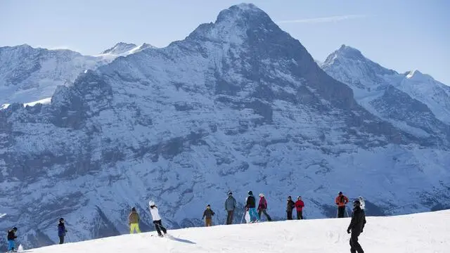 epa05741385 People are skiing with a view of the Eiger Mountain, at the First, above Grindelwald, in the Bernese Oberland, Switzerland, on a sunny day for winter sport activities on 22 January 2017. EPA/ANTHONY ANEX