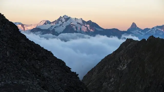 epa04863396 On the left the Mischabel mountains, Alphubel mountain with the Dom mountain (highest mountain of Switzerland) and on the right the Matterhorn mountain after sunrise seen from the Eggishorn mountain, in Fiesch, Switzerland, early 28 July 2015. EPA/DOMINIC STEINMANN
