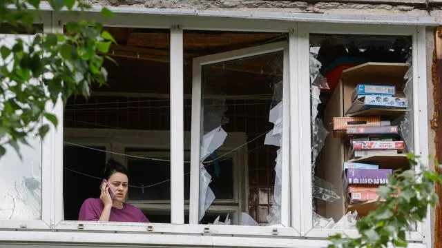 epaselect epa12072636 A woman speaks on a phone in her damaged flat at the site of an overnight drone strike that hit a residential area in Kyiv, Ukraine, 04 May 2025, amid the ongoing Russian invasion. At least eleven people were injured, including two children, in the strike on the residential area, according to the State Emergency Service report. Russia launched a large-scale overnight attack using 165 drones across all of Ukraine, according to the Air Force Command of Ukraine. EPA/SERGEY DOLZHENKO