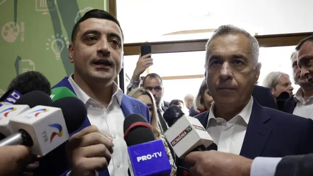 epa12111623 Presidential candidate and far-right party Alliance for the Union of Romanians (AUR) leader George Simion (L) accompanied by the banned candidate Calin Georgescu (R) talks to reporters after casting his ballot during the second round of presidential elections in Mogosoaia village, near Bucharest, Romania, 18 May 2025. Romanian voters are going to the polls for the runoff of the presidential election with around 18 million citizens eligible to vote, according to the Permanent Electoral Authority (AEP). EPA/ROBERT GHEMENT