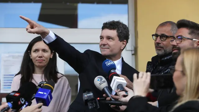 epaselect epa12111632 Nicusor Dan (C), Bucharest mayor and independent presidential candidate supported by the Force of Right (FD) accompanied by his partner Mirabela Gradinaru (L) talks to media after casting ballot during the second round of presidential elections in Fagaras, Romania, 18 May 2025. Romanian voters are going to the polls this weekend for the runoff of the presidential election with around 18 million citizens eligible to vote, according to the Permanent Electoral Authority (AEP). EPA/BOGDAN CRISTEL