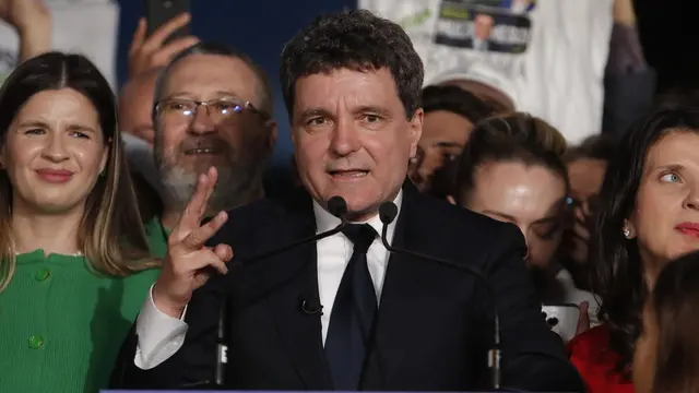 epa12114495 Nicusor Dan (C), Bucharest mayor and independent presidential candidate supported by the Force of the Right (FD), delivers his speech after the first exit poll results are announced in Cismigiu Park, Bucharest, Romania, 18 May 2025. The polls have closed in Romania, where voters cast their ballots this weekend in the runoff of the presidential election, with around 18 million citizens eligible to vote, according to the Permanent Electoral Authority (AEP). EPA/BOGDAN CRISTEL