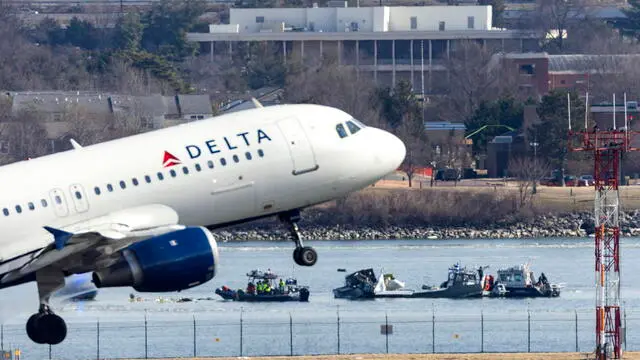 epa11864172 A Delta Airlines flight takes off from Ronald Reagan Washington National Airport in front of the wreckage of a commercial airplane that collided with a military helicopter, in Arlington, Virginia, USA, 30 January 2025. DC Fire and EMS Chief John Donnelly said no survivors are expected following the collision of an American Eagle Flight, with 60 passengers and four crew members on board, with a US Army Black Hawk helicopter carrying three US service members late on 29 January, over the Potomac River near Reagan Washington National Airport. EPA/JIM LO SCALZO