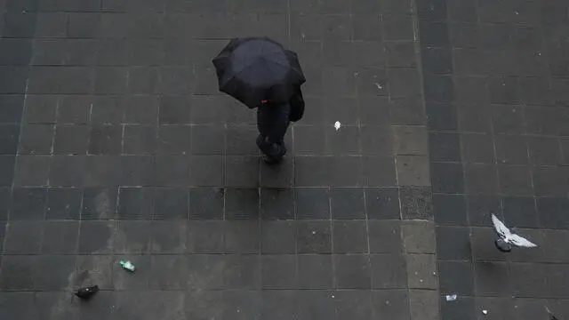 epa11847872 A person walks with an umbrella amid rainfall in La Paz, Bolivia, 23 January 2025. According to Juan Carlos Calvimontes, Bolivia's Vice Minister of Civil Defense, the recent rainy season has resulted in floods and landslides in several areas of the country, killing at least 18 people and affecting at least 50,000 families. EPA/LUIS GANDARILLAS