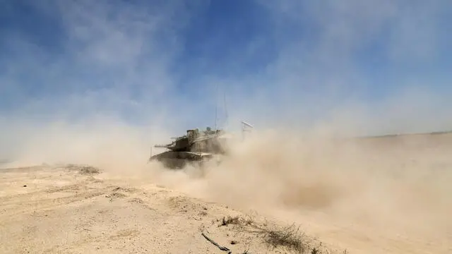epa12118906 Israeli Merkava tanks maneuver towards the southern Gaza Strip border near Khan Yunis, seen from southern Israel, 20 May 2025. Israel's military continued to strike targets across the Gaza Strip as part of its 'Gideon's Chariots' operation. EPA/ATEF SAFADI
