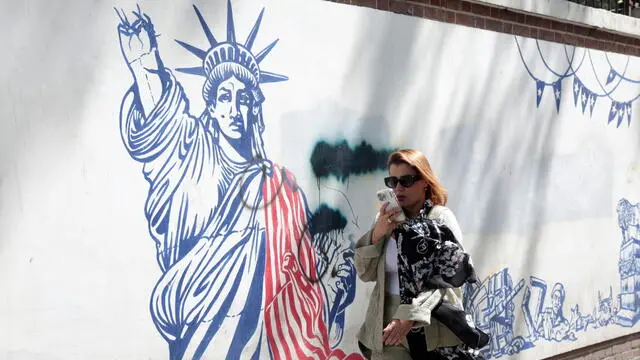 epa12090198 A woman walks next to an anti-US mural in front of the former US embassy in Tehran, Iran, 11 May 2025. Iran and the US hold their fourth round of nuclear talks in Muscat on the same day. EPA/ABEDIN TAHERKENAREH