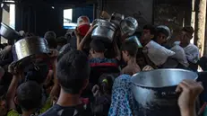 epa12122618 Hundreds of displaced Palestinians gather outside the Sokar Charity Kitchen in Gaza City to receive limited food rations,21 May, 2025. Kitchen officials say their stocks ran out today due to the suspension of humanitarian aid entering the Gaza Strip. EPA/HAITHAM IMAD