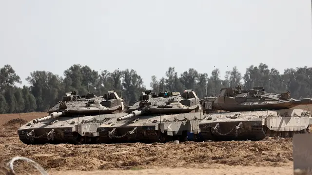 epa12124615 Israeli Merkava tanks gather at the southern Gaza Strip border near Khan Yunis, as seen from southern Israel, 22 May 2025, as Israel's military continues to strike targets across the Gaza Strip as part of its 'Gideon's Chariots' operation. EPA/ATEF SAFADI