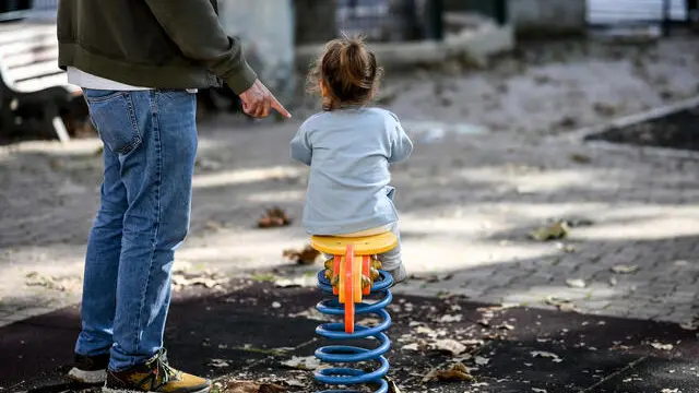 Un padre con sua figlia in un parco giochi di Roma, 31 ottobre 2024. ANSA/ALESSANDRO DI MEO (generica, simbolica, genitore, genitori, padre, single, figlia, bambina, figli, giochi, parco, autunno, inverno, bambini, giocare)
