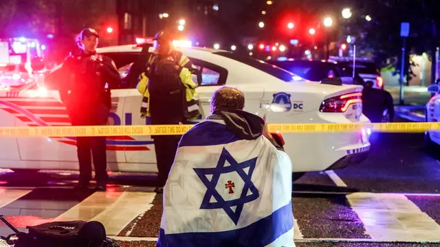 epaselect epa12124462 A man with an Israeli flag draped on his shoulders near the scene where two people were shot and killed near the Capital Jewish Museum in Washington, DC, USA, 22 May 2025. According to a social media post by the US Homeland Security Secretary Kristi L. Noem, the two people killed were staff members at the Israeli embassy. EPA/WILL OLIVER