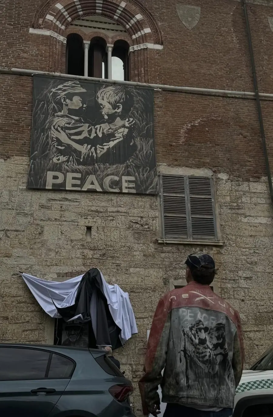 Lo stendardo Peace by peace sulla facciata del Broletto