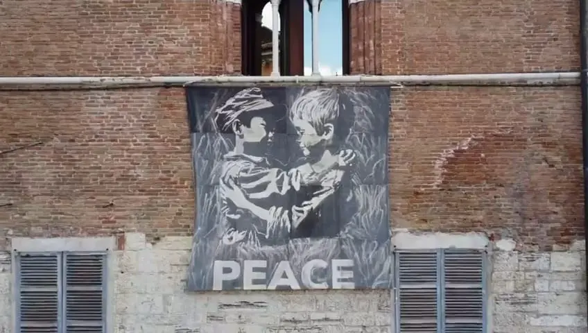 Lo stendardo Peace by peace sulla facciata del Broletto
