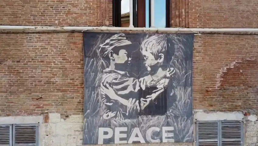 Lo stendardo Peace by peace sulla facciata del Broletto