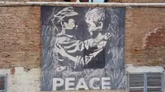 Lo stendardo Peace by peace sulla facciata del Broletto