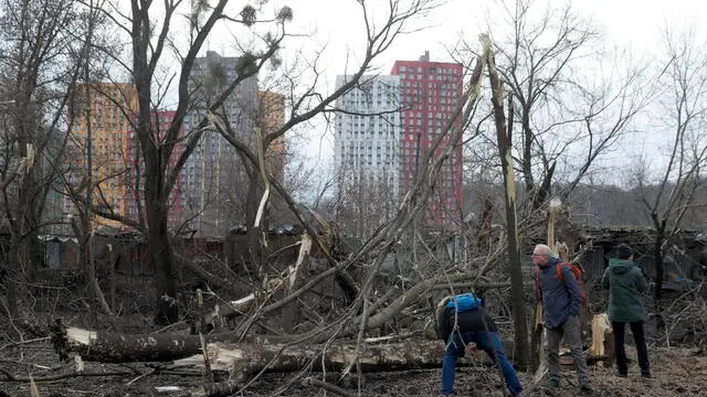 epa10431279 People look at destroyed trees after a misssile strike hit Kiyv, Ukraine, 26 January 2023. Russian missile strikes hit various energy infrastructure targets across Ukraine. According to Ukraine's energy minister Halushchenko, emergency power outages have been introduced and the most difficult situation were currently observed in Kyiv, Odesa and Vinnytsia oblasts. EPA/SERGEY DOLZHENKO