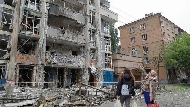 epa12133274 People look at a residential building struck by a drone following an overnight strike in Kyiv, Ukraine, 25 May 2025, amid the ongoing Russian invasion. At least 12 people were killed across Ukraine, including children, and dozens more were injured, after Russia launched a large-scale attack with at least 69 missiles and nearly 300 drones in 13 different regions, the State Emergency Service confirmed on 25 May. EPA/SERGEY DOLZHENKO