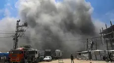 epa12127722 A Palestinian walks in the middle of a road as smoke rises following an Israeli airstrike west of Gaza City, in Gaza Strip, 23 May 2025. More than 53,700 Palestinians have been killed in the Gaza Strip, according to the Palestinian Ministry of Health, since Israel launched a military campaign in the strip in response to a cross-border attack led by the Palestinian militant group Hamas on 07 October 2023, in which about 1,200 Israelis were killed and more than 250 taken hostage. EPA/MOHAMMED SABER