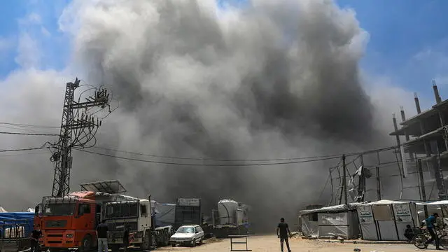 epa12127722 A Palestinian walks in the middle of a road as smoke rises following an Israeli airstrike west of Gaza City, in Gaza Strip, 23 May 2025. More than 53,700 Palestinians have been killed in the Gaza Strip, according to the Palestinian Ministry of Health, since Israel launched a military campaign in the strip in response to a cross-border attack led by the Palestinian militant group Hamas on 07 October 2023, in which about 1,200 Israelis were killed and more than 250 taken hostage. EPA/MOHAMMED SABER