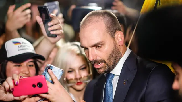 epa10933687 The deputy of the Brazilian far-right, Eduardo Bolsonaro, son of former president Jair Bolsonaro, greets supporters after his arrival in the country to offer his support to the presidential candidate of La Libertad Avanza (LLA), Javier Milei, during the elections this Sunday, in Buenos Aires, Argentina, 22 October 2023. Eduardo Bolsonaro himself reaffirmed his visit through a publication on his X (former Twitter) account in which - citing an article from the newspaper La NaciÃ³n - he asked to be included as part of the ?ultra-right.? EPA/Juan Ignacio Roncoroni