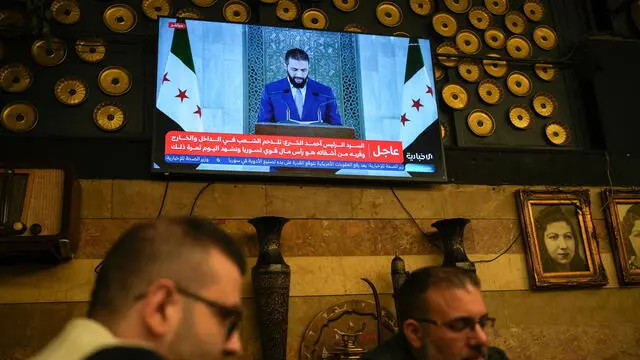 epa12100745 Syrians watch a speech by Syrian President Ahmad al-Sharaa, after Trump's decision to lift sanctions on Syria, at Al-Rawda Cafe in central Damascus, Syria, 14 May 2025. EPA/AHMAD FALLAHA