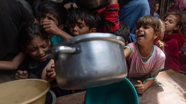 epa12112756 Hundreds of internally displaced Palestinians gather outside a charity kitchen in Gaza city to receive limited food rations, 18 May 2025. Kitchen administrators warn their stocks would run out in two days due to the suspension of humanitarian aid entering the Gaza Strip. According to the UN half a million people, or one in five people in the Strip are facing starvation while the entire population of the Gaza Strip continues to face a critical risk of famine following 19 months of conflict, mass displacement and severe restrictions on humanitarian aid. EPA/HAITHAM IMAD