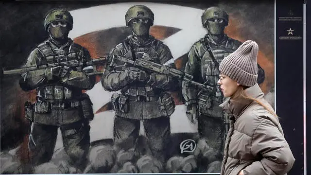 epa11749490 A woman walks past the exhibition 'Together to Victory' of military posters created by artists and dedicated to Russian soldiers in the center of St. Petersburg, Russia, 30 November 2024. EPA/ANATOLY MALTSEV