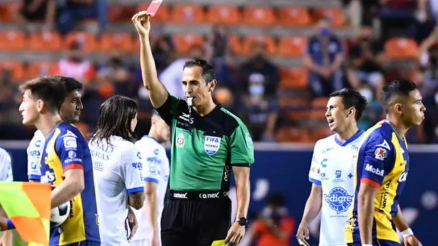 epa09389320 Central referee Luis Enrique Santander (C) shows a red card for an expulsion to Bryan Olivera (L) from Queretaro during the Liga MX Apertura Tournament soccer match between Atletico San Luis and Queretaro at the Alfonso Lastras Stadium in San Luis Potosi, Mexico, 02 August 2021. EPA/Victor Cruz
