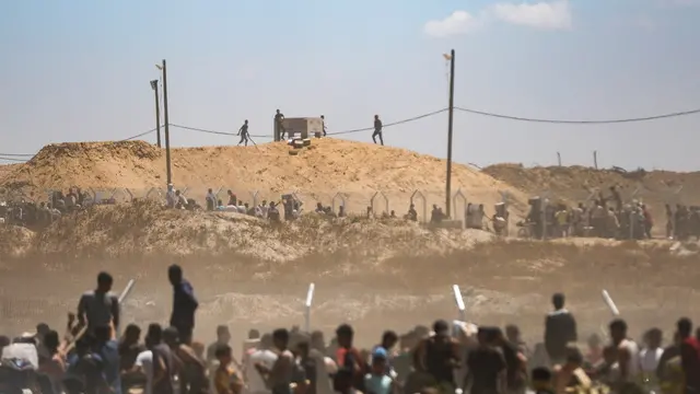 epa12143211 Palestinians carry aid supplies received from the US-backed Gaza Humanitarian Foundation through an area known as the Netzarim Corridor, central Gaza Strip, 29 May 2025. According to the UN half a million people, or one in five people in the Strip are facing starvation while the entire population of the Gaza Strip continues to face a critical risk of famine following 19 months of conflict, mass displacement and severe restrictions on humanitarian aid. EPA/HAITHAM IMAD