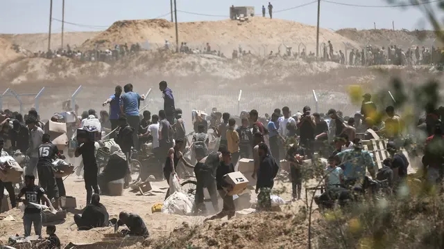 epaselect epa12143208 Palestinians carry aid supplies received from the US-backed Gaza Humanitarian Foundation through an area known as the Netzarim Corridor, central Gaza Strip, 29 May 2025. According to the UN half a million people, or one in five people in the Strip are facing starvation while the entire population of the Gaza Strip continues to face a critical risk of famine following 19 months of conflict, mass displacement and severe restrictions on humanitarian aid. EPA/HAITHAM IMAD