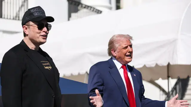 epa11956958 Tesla CEO and Senior Advisor to the President of the United States Elon Musk (L) looks on as US President Donald Trump (R) speaks in front of Tesla vehicles at the White House in Washington, D.C., USA, 11 March 2025. President Trump has said he will buy a Tesla to support Tesla and Elon Musk after recent attacks on Tesla charging stations and calls for boycotts of Tesla products. EPA/SAMUEL CORUM / POOL