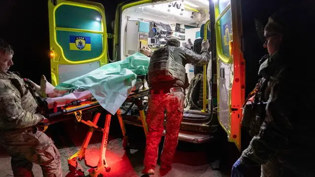epa12136495 Ukrainian soldiers shift an injured comrade for medical attention at a stabilization point near the frontline in Kharkiv area, Ukraine, 25 May 2025 (issued 26 May 2025), amid the Russian invasion. The Ukrainian Army medical facilities are the first point of care for wounded soldiers before they are transferred to hospitals. EPA/YEVHEN TITOV