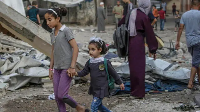 epa12136484 Palestinians sisters walk near the rubble of the Jerjawi school destroyed following an Israeli airstrike in the Al Daraj neighborhood of Gaza City on 26 May 2025. According to the Palestinian Health Ministry in Gaza over 30 Palestinians were killed in the airstrike in the early hours of the morning. More than 53,900 Palestinians have been killed in the Gaza Strip, according to the Palestinian Ministry of Health, since Israel launched a military campaign in the strip in response to a cross-border attack led by the Palestinian militant group Hamas on 07 October 2023, in which about 1,200 Israelis were killed and more than 250 taken hostage. EPA/MOHAMMED SABER
