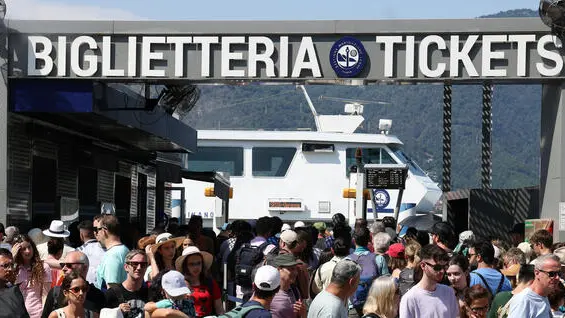 La coda per accedere ai battelli della navigazione sul lago di Como, 17 Agosto 2023. ANSA / MATTEO BAZZI