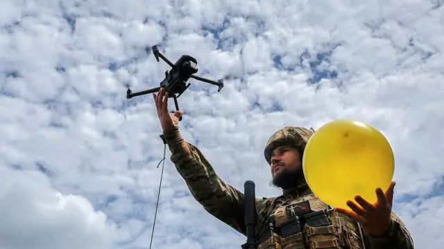 epa12145130 A Ukrainian serviceman lifts a drone attached to a balloon for target practice during anti-drone training at an undisclosed location near the frontline in the Kharkiv region, northeastern Ukraine, 30 May 2025, amid the Russian invasion. Drone activity, including intelligence and strike drones, pose a challenge for militaries and civilians near frontlines, as these can fly up to 40 km, reaching previously considered deep rear areas. EPA/SERGEY KOZLOV
