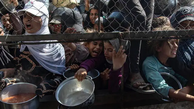 epa12144621 Internally displaced Palestinians gather outside a charity kitchen to receive limited rations amid a shortage of food, in Khan Younis, southern Gaza Strip, 30 May 2025. The United Nations has warned that "the entire population of Gaza is facing the risk of famine" since Israel closed border crossings on 02 March 2025, preventing the entry of essential supplies. The Gaza Government Media Office reported on 24 May that at least 58 people died due to malnutrition, and nearly 250 others due to a lack of food and medicine. EPA/HAITHAM IMAD