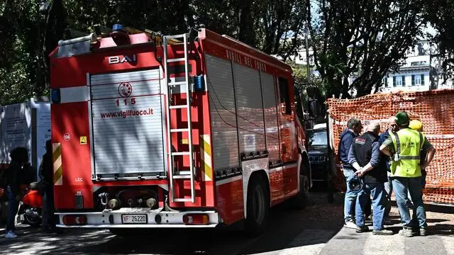 I Vigili del Fuoco e alcuni dei colleghi degli operai, davanti all'entrata del cantiere per la costruzione della stazione della metropolitana di Piazza Corvetto, dove per il crollo di un mro tre oprai sono rimasti feriti, anche in modo grave. Genoa, 08 maggio 2025. ANSA/LUCA ZENNARO (Edilizia, edili, incidenti edilizia, operai feriti, edili)