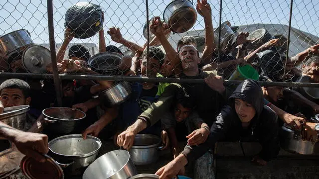 epa12144623 Internally displaced Palestinians gather outside a charity kitchen to receive limited rations amid a shortage of food, in Khan Younis, southern Gaza Strip, 30 May 2025. The United Nations has warned that "the entire population of Gaza is facing the risk of famine" since Israel closed border crossings on 02 March 2025, preventing the entry of essential supplies. The Gaza Government Media Office reported on 24 May that at least 58 people died due to malnutrition, and nearly 250 others due to a lack of food and medicine. EPA/HAITHAM IMAD