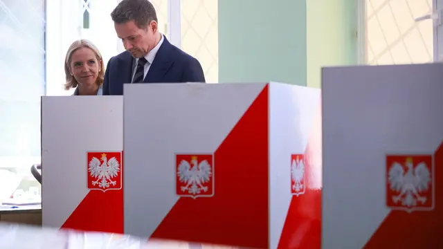 epa12148907 KO presidential candidate and Warsaw Mayor Rafal Trzaskowski (R), with his wife Malgorzata (L), cast their votes at a polling station in Warsaw, Poland, 01 June 2025. Voting in the second round of the presidential election is underway, with voting silence in effect until polls close. The election began at 7 a.m. and is scheduled to end at 9 p.m., as Poles choose their next president for a five-year term. EPA/LESZEK SZYMANSKI POLAND OUT