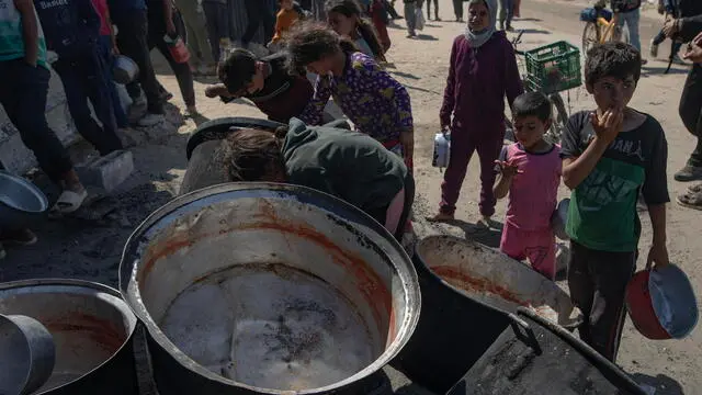 epa12144625 Internally displaced Palestinians gather outside a charity kitchen to receive limited rations amid a shortage of food, in Khan Younis, southern Gaza Strip, 30 May 2025. The United Nations has warned that "the entire population of Gaza is facing the risk of famine" since Israel closed border crossings on 02 March 2025, preventing the entry of essential supplies. The Gaza Government Media Office reported on 24 May that at least 58 people died due to malnutrition, and nearly 250 others due to a lack of food and medicine. EPA/HAITHAM IMAD