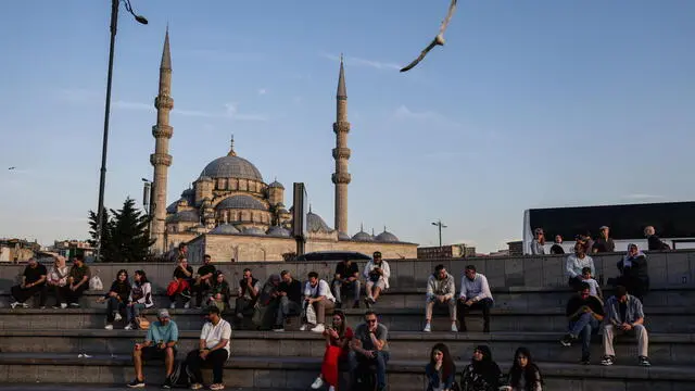 epa12141461 People sit in front of the Eminonu New Mosque during sunset in Istanbul, Turkey, 28 May 2025. EPA/ERDEM SAHIN