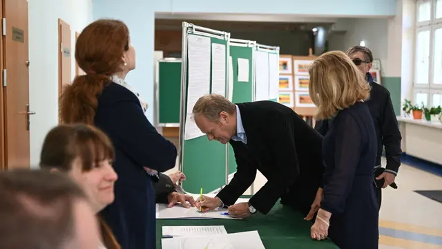 epa12112213 Polish Prime Minister Donald Tusk (2R) with his wife Malgorzata (R) vote at a polling station during Poland's presidential elections in Sopot, Poland, 18 May 2025. Nearly 29 million Poles are eligible to vote in these elections, where 13 candidates are competing to elect their next president for a five-year term. A potential runoff is set for 1 June if no candidate achieves an outright majority in the first round. EPA/MARCIN GADOMSKI POLAND OUT