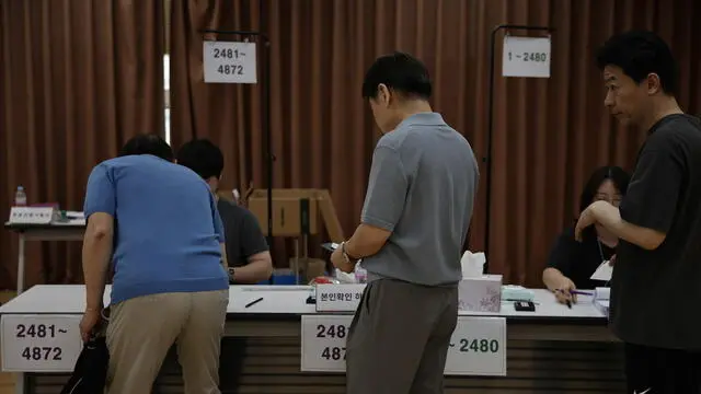 epa12151795 Voters check their identification cards at a polling station in Seoul, South Korea, 03 June 2025. South Korea holds its presidential election on 03 June 2025. EPA/ANDRES MARTINEZ CASARES
