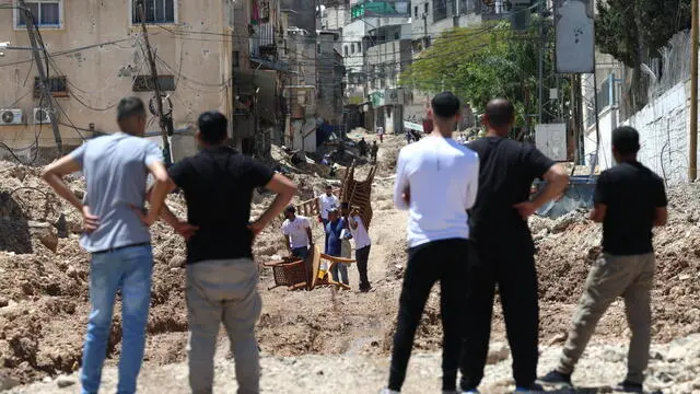 epa12143301 Palestinians carry their belongings along a road in the Tulkarem refugee camp during an Israeli military operation, near the West Bank city of Tulkarem, 29 May 2025. According to the Palestinian news agency Wafa, Israeli forces continued their operation in the city of Tulkarem and its refugee camp demolishing dozens of residential buildings. EPA/ALAA BADARNEH