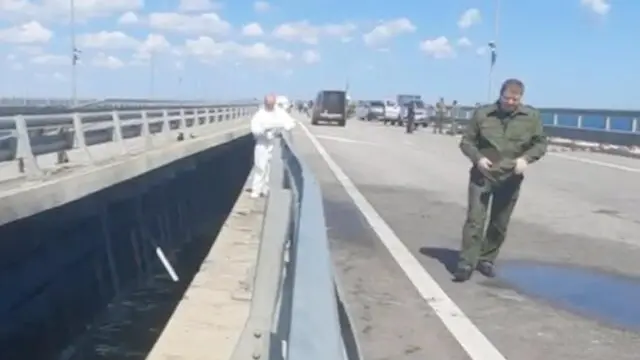 epa10751242 A still image taken from a handout video made available by Russia's Investigative Committee shows Russian Investigative Committee officers examining the damage on the Kerch Bridge connecting Crimea to mainland Russia, 17 July 2023. The Investigative Committee of Russia said that one of the sections of the Crimean bridge was damaged in the night of 16 to 17 July. Two civilians, a man and a woman, were killed while driving a car across the bridge; their minor daughter was injured in the incident, the statement added. Russia has blamed 'special services of Ukraine' for the 'attack', and said it launched a criminal investigation into the incident. EPA/INVESTIGATIVE COMMITTEE OF THE RUSSIAN FEDERATION -- BEST QUALITY AVAILABLE -- MANDATORY CREDIT -- HANDOUT EDITORIAL USE ONLY/NO SALES