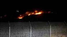 epa08564951 A fire seen from the Israeli side of the border on a Syrian observation post, caused by an Israeli army helicopters attack, on the Israeli-Syrian border next to the village of Majdal Shams, late 24 July 2020. An Israeli army spokesperson announced that Israeli helicopters struck military targets in southern Syria belonging to the Syrian Armed Forces. A number of targets were struck, including SAF observation posts and intelligence collection systems located in SAF bases. EPA/ATEF SAFADI
