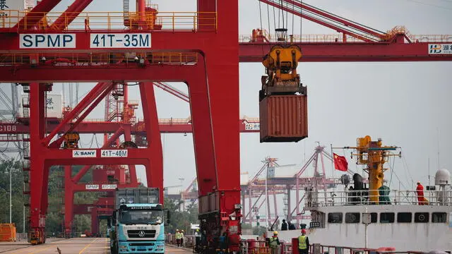 epa12128133 A crane loads containers from a cargo ship onto trucks at Yangluo Port during an organized press trip in Wuhan, Hubei province, China, 23 May 2025. Yangluo Port, located on the north bank of the Yangtze River in eastern Wuhan, is a key deep-water port with depths ranging from 7 to 15 meters. It is the largest container hub along the middle and upper reaches of the Yangtze River, serving as a vital 'gateway to the sea' for central and western China. EPA/ALEX PLAVEVSKI